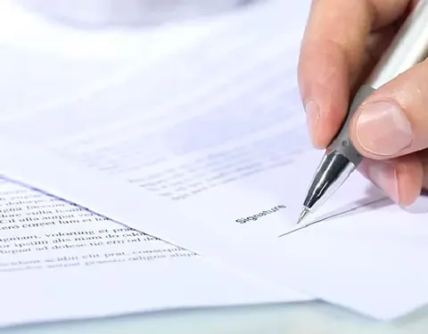 A signature being written on a document