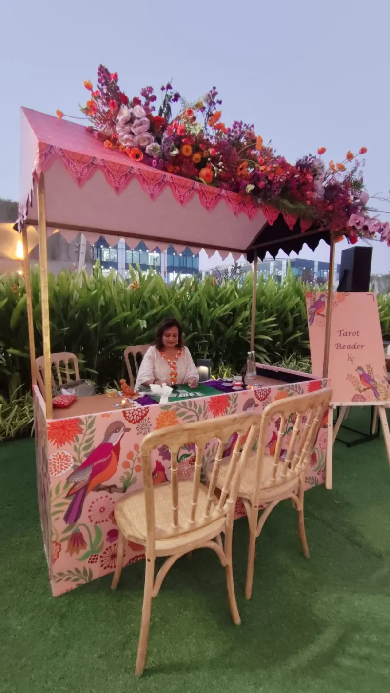 Tarot table under a flower canopy at the Jio World Drive event