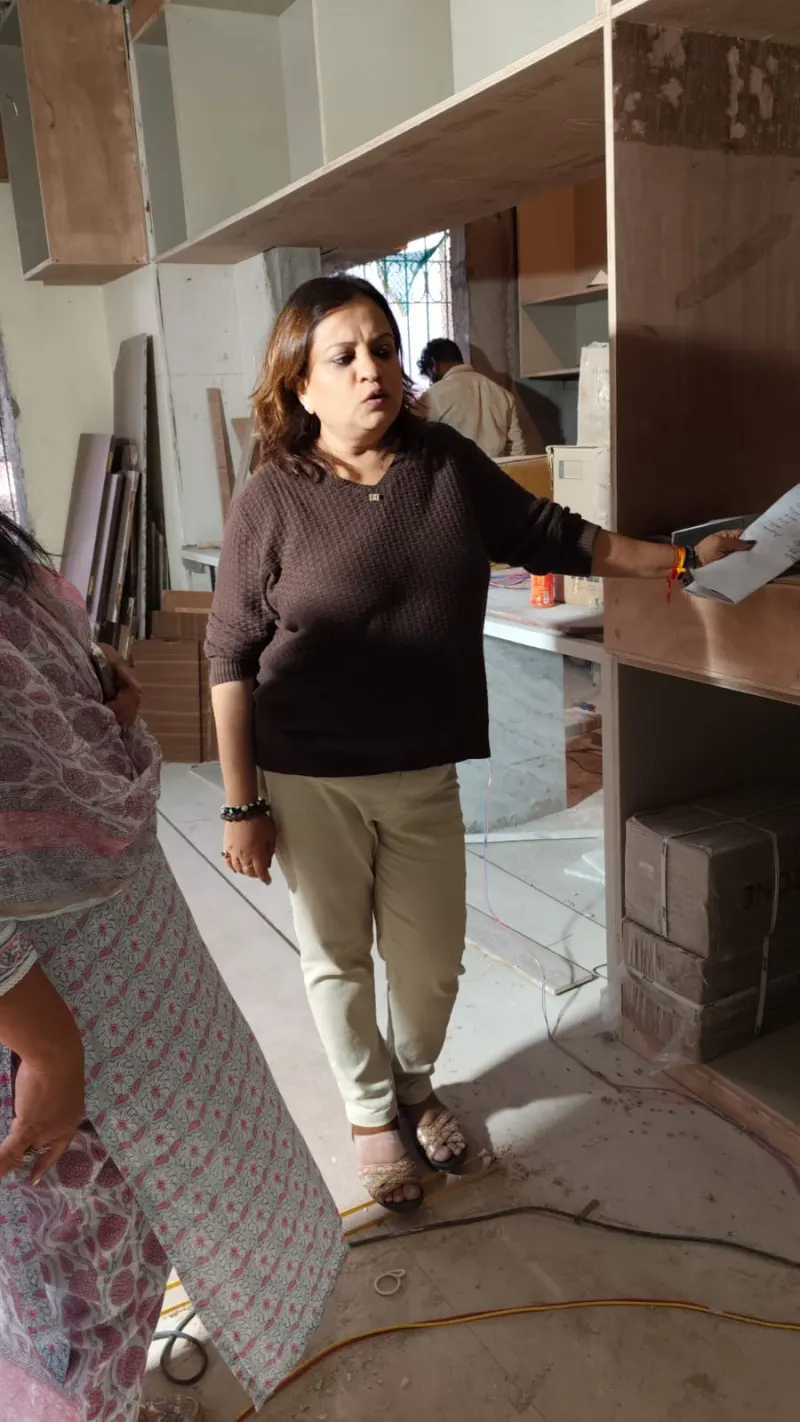 Dr. Riddhe Sshilpi guiding the installation team in the kitchen area of a South Mumbai home