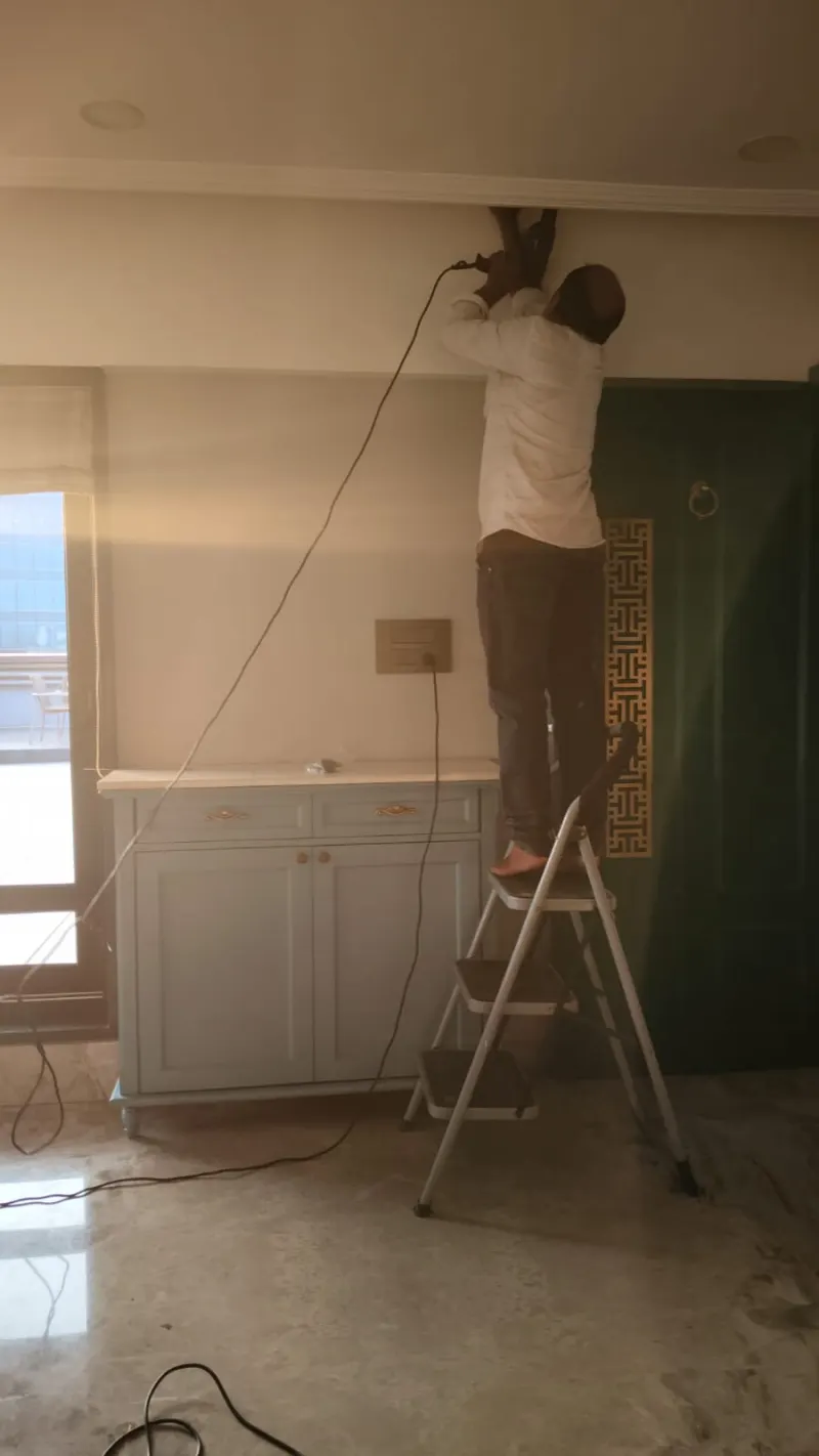 Technician installing a Vastu correction near the ceiling in an Andheri home
