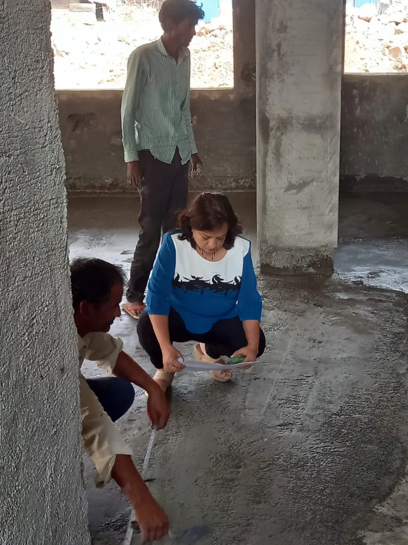 Marking and measuring directions on the floor slab during a Vastu visit in Lonavala